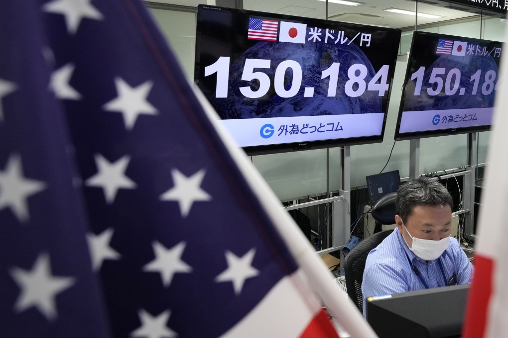 A dealer works as displays show the exchange rate between the Japanese yen and the US dollar at a foreign exchange trading company in Tokyo on October 21. The yen continues its fall against the US dollar, hitting a 32-year low, to remain in the 150 range. Photo: EPA-EFE