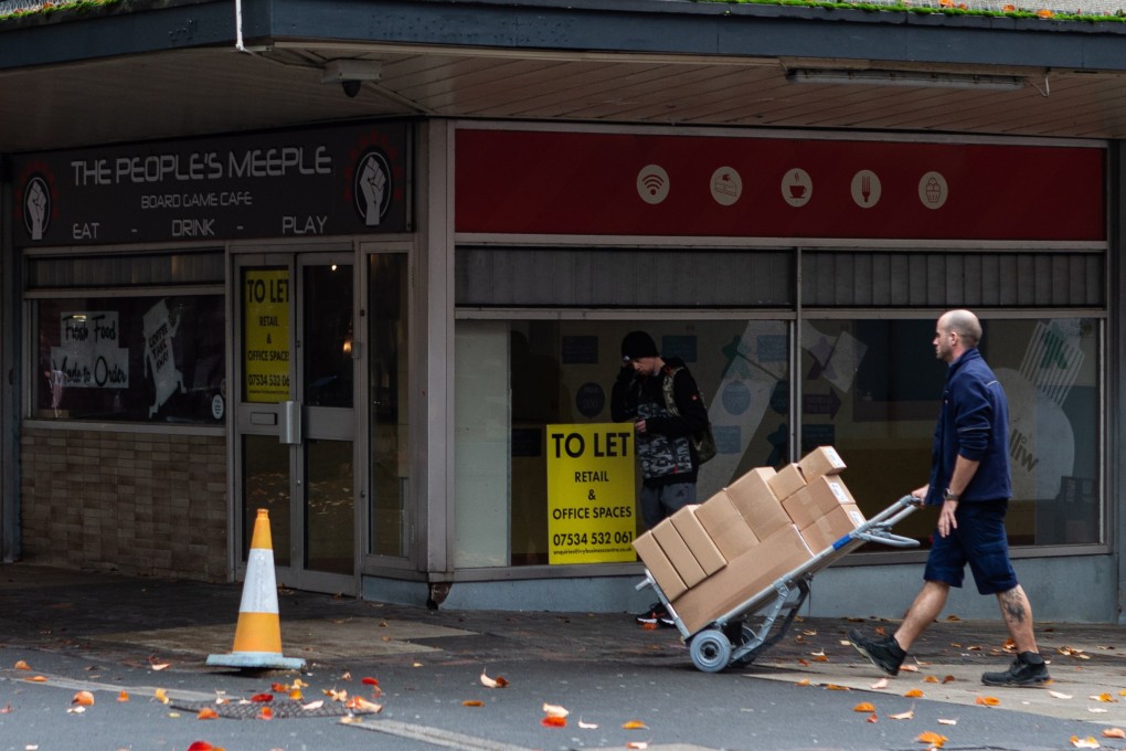 A delivery courier walks past an empty retail unit in Huddersfield, England, on October 21. The Office for National Statistics reported that retail sales fell in Britain in September, with food sales suffering the largest drop. Photo: EPA-EFE