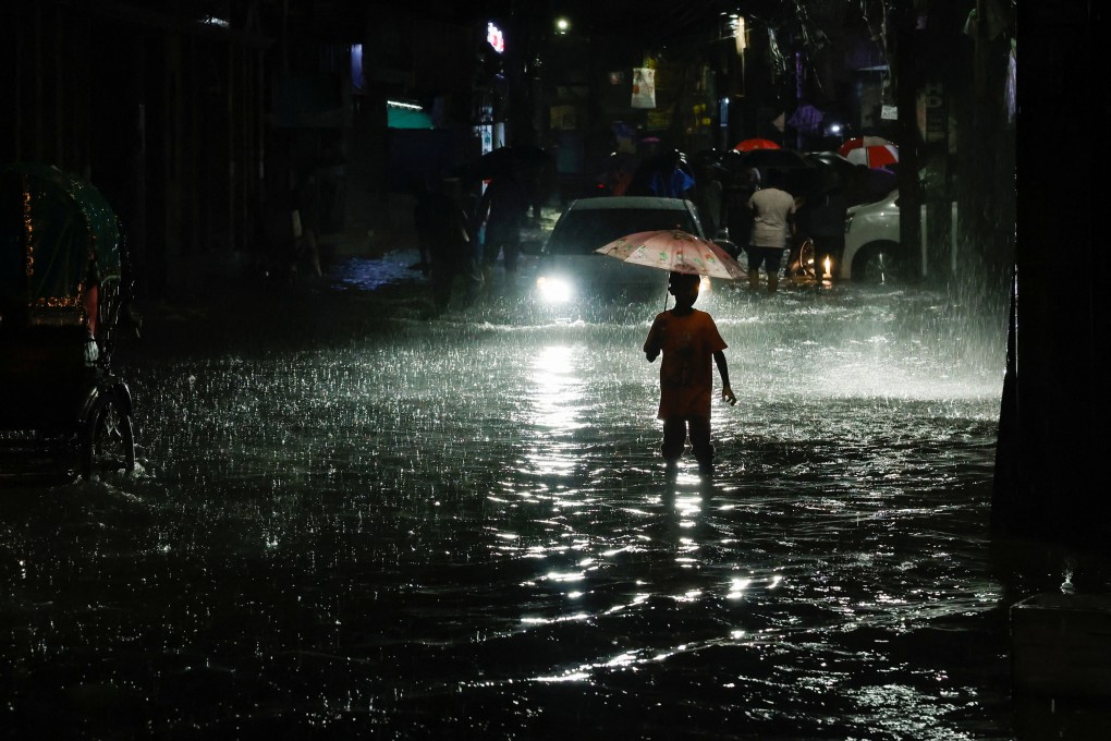 A boy in Dhaka wades through a street flooded by continuous rain before Cyclone Sitrang made landfall on Monday. Photo: Reuters