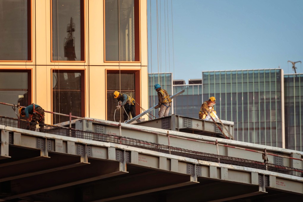 Construction workers in Shanghai on October 24. By relying on funds raised through the capital market and commercial banks, China makes its infrastructure investments far more costly than necessary. Photo: EPA-EFE