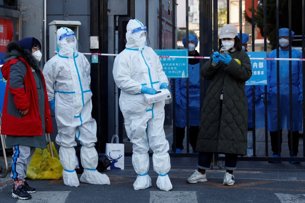 Security personnel in protective suits stand outside a residential compound under lockdown on October 22 as outbreaks of Covid-19 continue in Beijing. Photo: Reuters