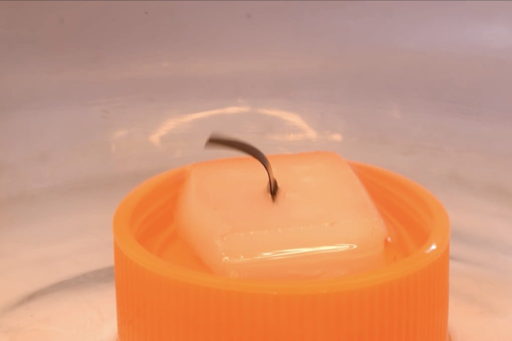 Scientists placed an upright piece of film in a pool of ethanol and put the device under infrared light. The film moved back and forth, with its energy ultimately powering a small engine. Photo: Liu Zunfeng