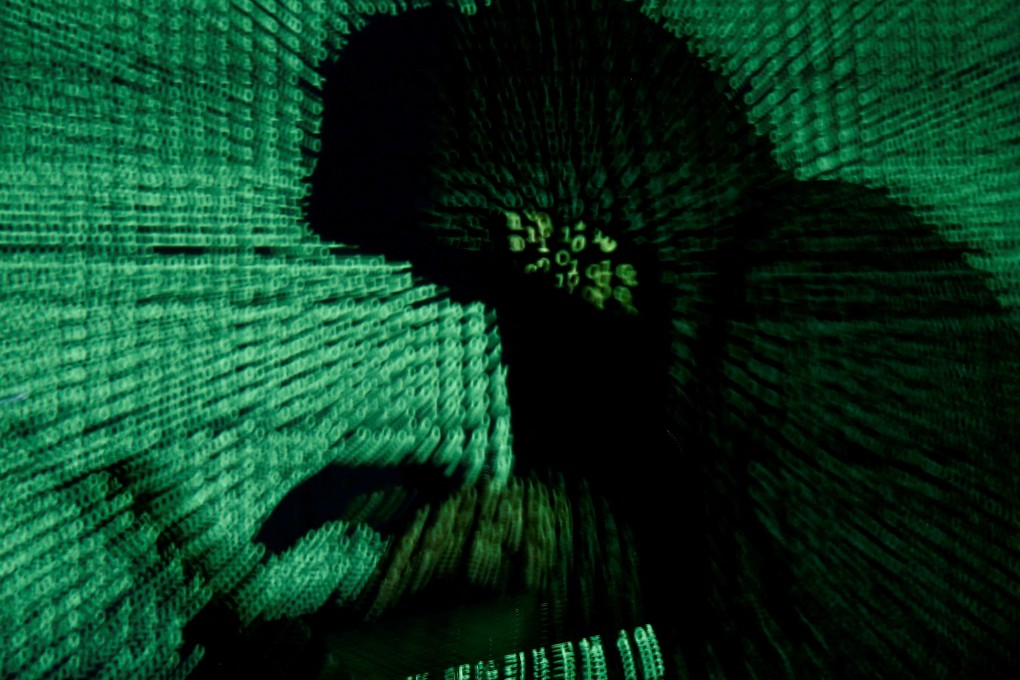A man holds a laptop computer as cyber code is projected on him in this illustration picture taken on May 13, 2017. Photo: Reuters