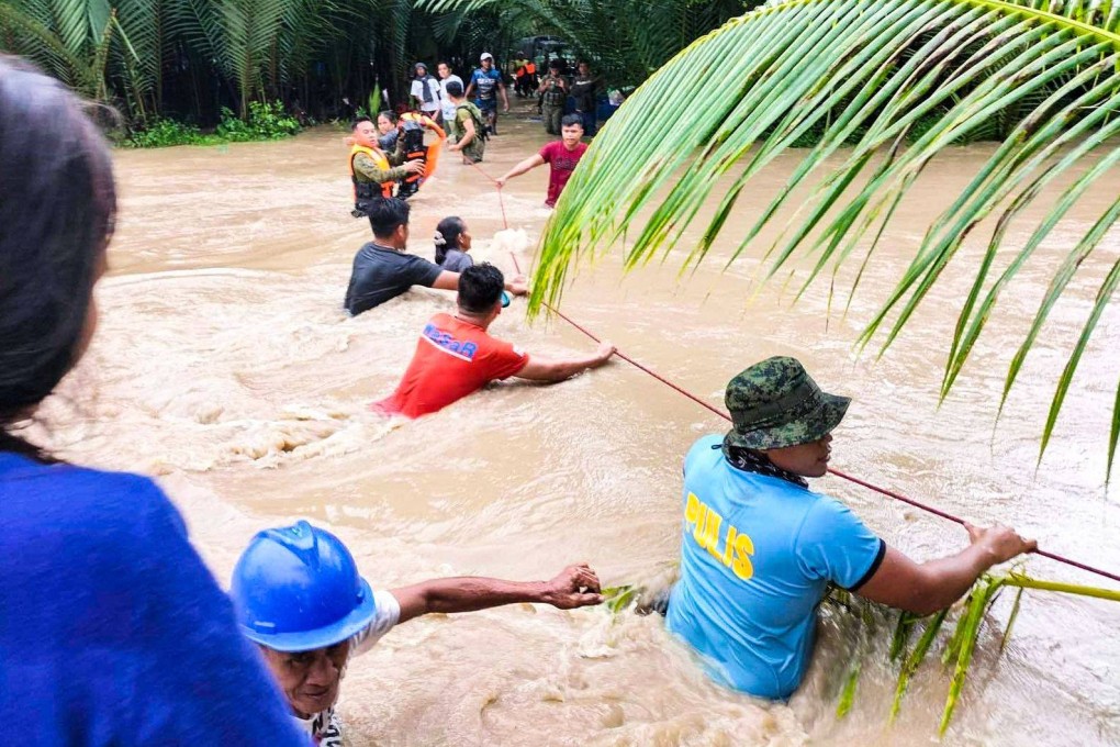 Rescuers help residents evacuate in Sultan Kudarat, Philippines, due to flooding brought by Tropical Storm Nalgae. Photo: AFP
