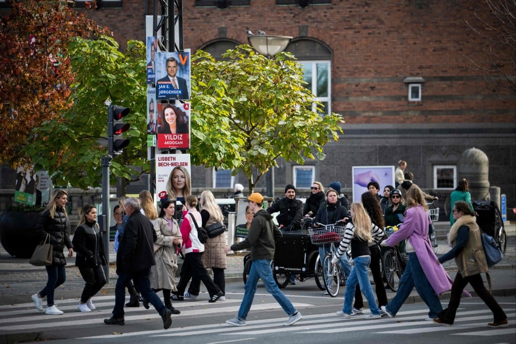 Election campaign posters are seen as people walk along the street in Copenhagen. The next general election for the Danish parliament will take place on November 1, 2022. Photo: AFP
