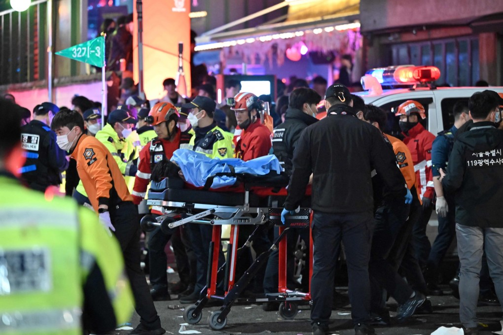 A person, believed to have suffered from cardiac arrest, is transported on a stretcher in the popular nightlife district of Itaewon in Seoul on Saturday. Photo: AFP