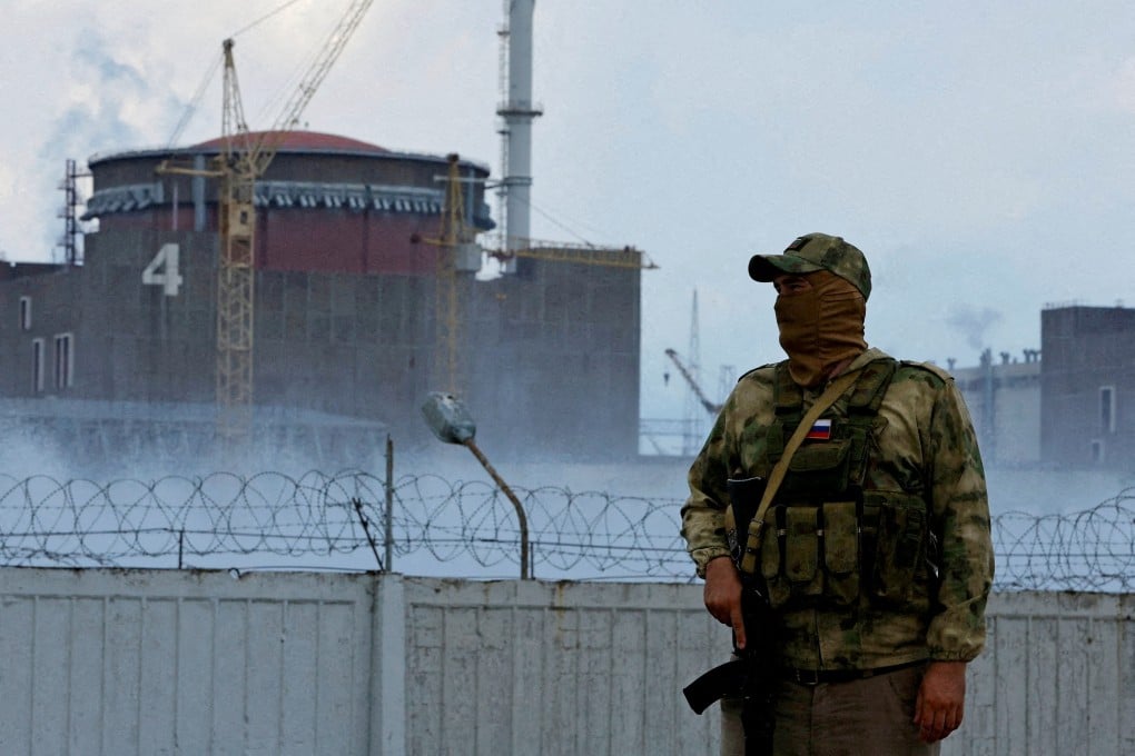 A serviceman with a Russian flag on his uniform stands guard near the Zaporizhzhia Nuclear Power Plant during the Ukraine invasion. Photo: Reuters