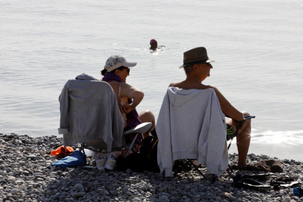 People enjoy a warm and sunny autumn day on the beach of the Promenade des Anglais in Nice, France. Photo: Reuters