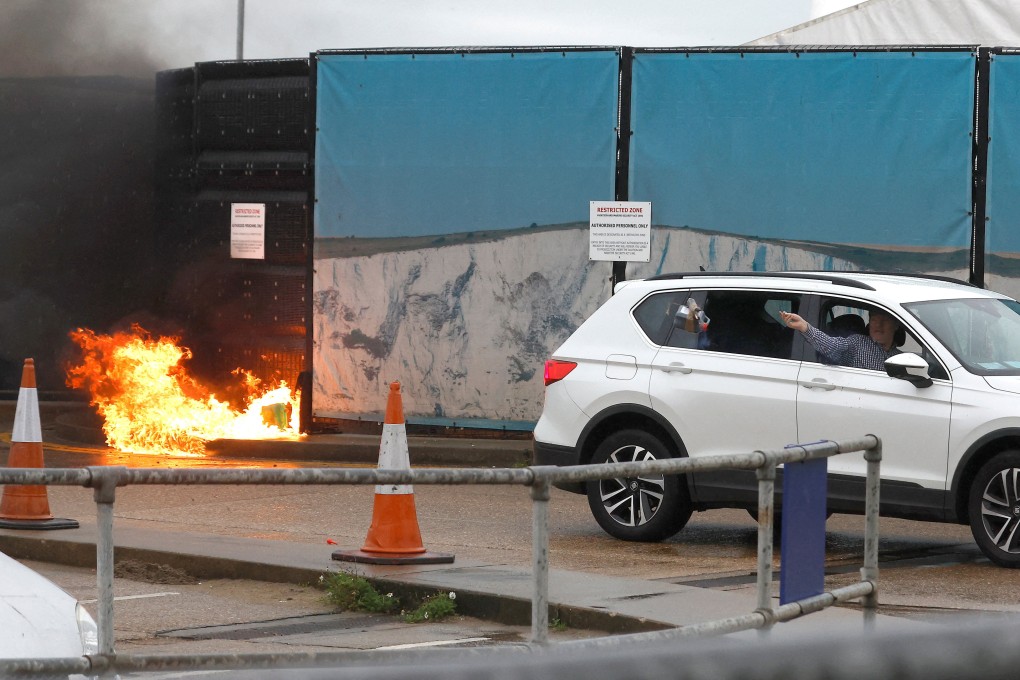 A man throws an object out of a car window next to the Border Force centre after a firebomb attack in Dover. Photo: Reuters