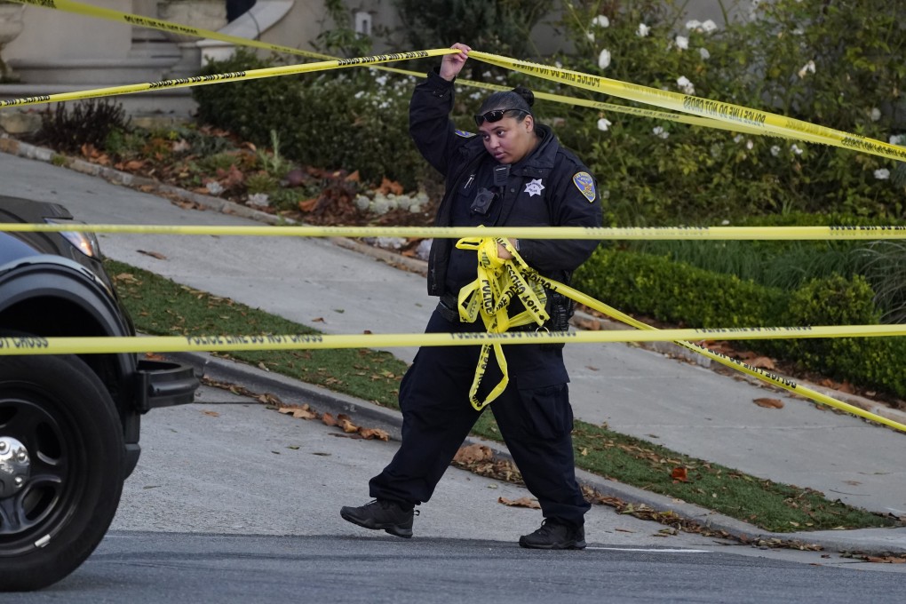 A police officer rolls out more yellow tape below the home of House Speaker Nancy Pelosi and her husband Paul Pelosi in San Francisco. Photo: AP