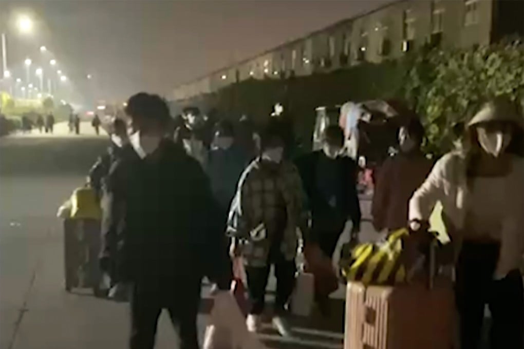 People with suitcases and bags are seen leaving from a Foxconn compound in Zhengzhou in central China on Saturday. Photo: Hangpai Xingyang via AP