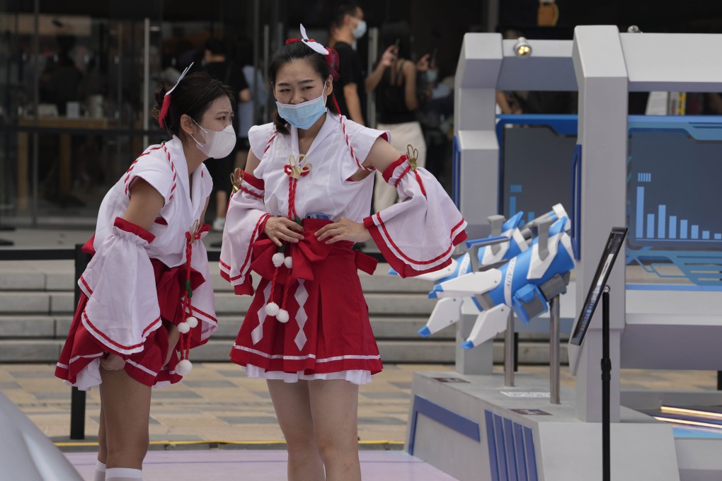 Staff are seen at a booth promoting Tencent’s popular Honor of Kings online game in Beijing. Photo: AP Photo