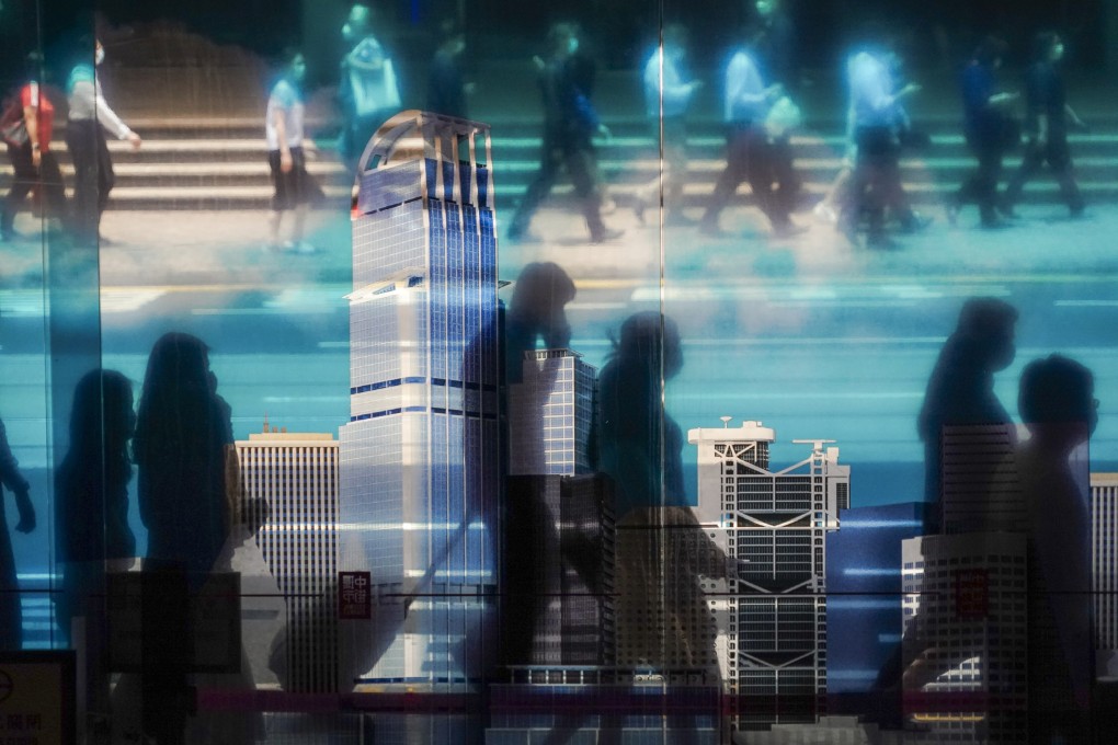 People walk past a transparent poster in Central Market on June 2. Hong Kong needs a plentiful supply of skilled local and non-local workers to maintain and enhance the city’s competitiveness. Photo: Felix Wong