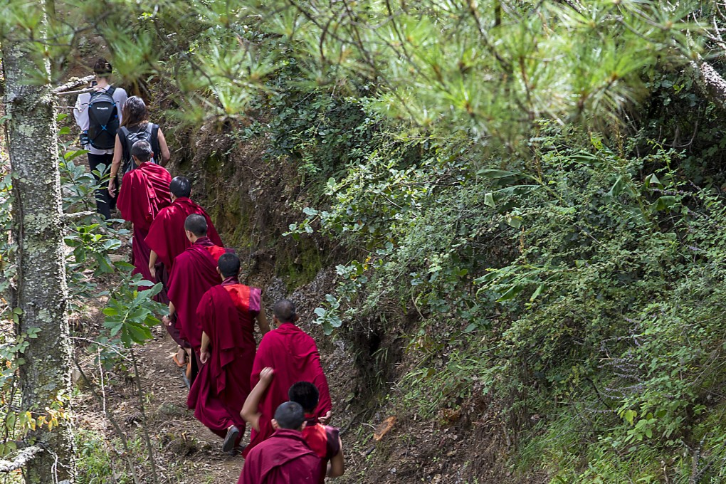 Hikers and monks walk along the Trans Bhutan Trail to mark its reopening. The 400km route linking villages in the kingdom fell into disrepair when it started building roads, but has been restored. Photo: Tim Pile