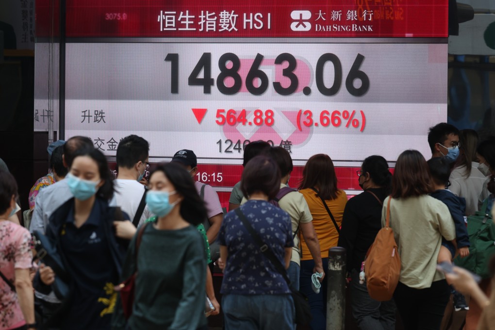 Pedestrians walk past an electronic billboard displaying the Hang Seng Index closing figure in Central on October 28. Photo: Yik Yeung-man