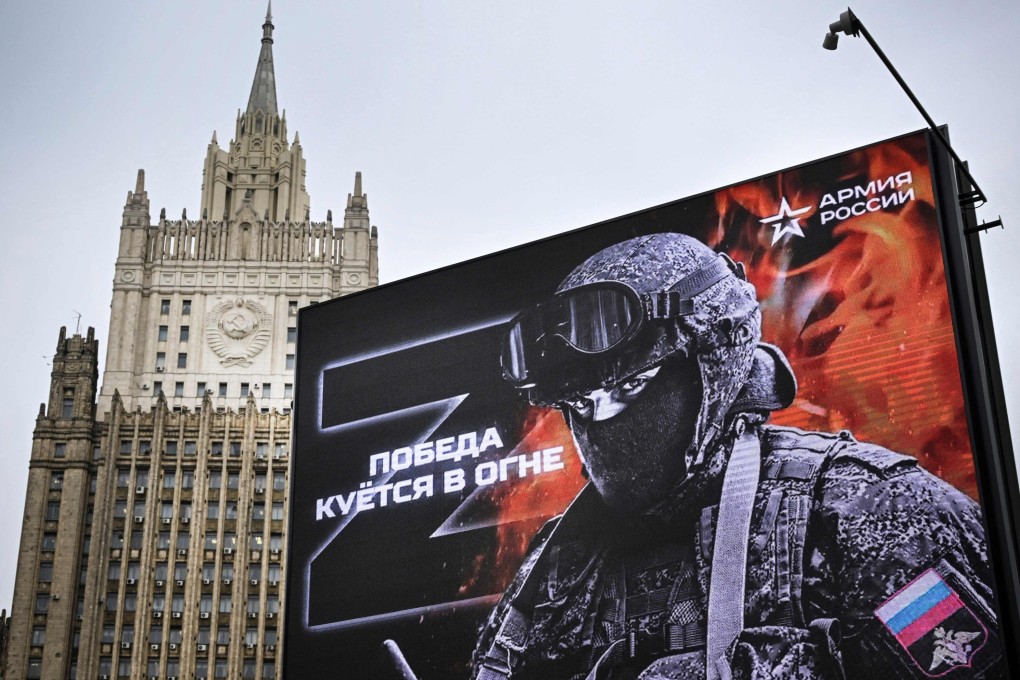 The Russian Foreign Ministry building behind a billboard that reads: “Victory is being Forged in Fire”. Photo: AFP