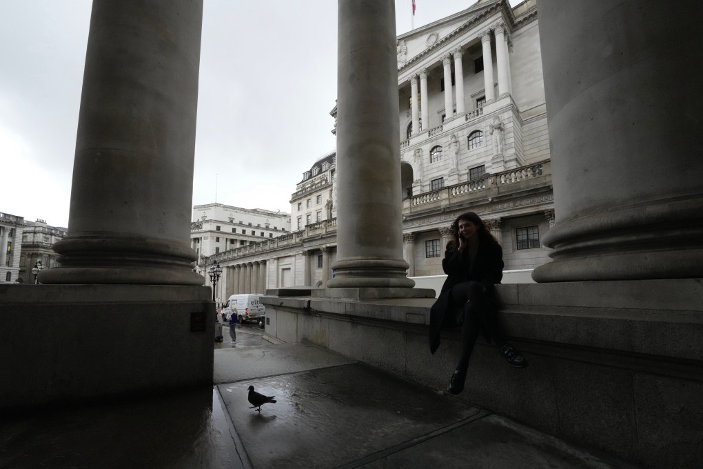 A woman sits in front of the Bank of England in London on November 3. The central bank recently announced its biggest interest rate increase in three decades. Photo: AP