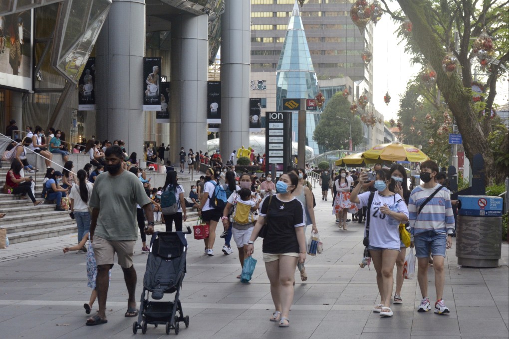 People wearing protective face masks walk along the Orchard Road shopping area in Singapore. Photo: AP
