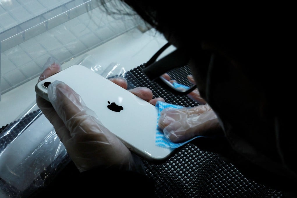 A worker cleans a used iPhone at an operations centre of Belong, a unit of Itochu Corp that sells used smartphones online, in Zama, located in Japan's Kanagawa Prefecture, on October 27, 2022. Photo: Reuters