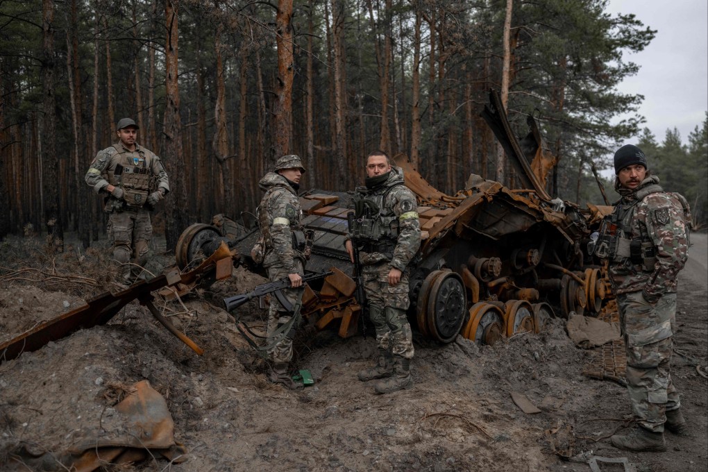 Ukrainian soldiers and volunteer fighters inspect a destroyed Russian tank in eastern Ukraine on November 10. Photo: AFP
