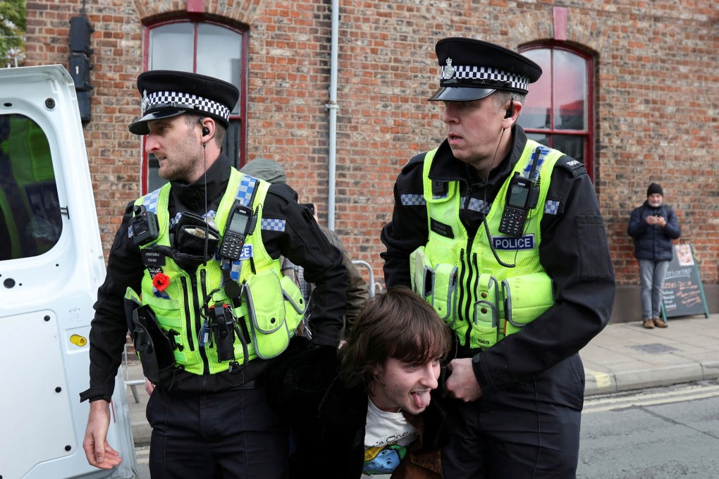 Police officers carry a man who threw an egg at King Charles to a police van in York on Wednesday. Photo: Reuters