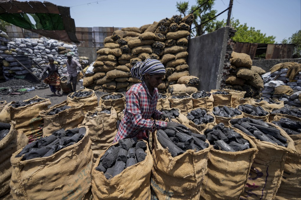 A woman works at a coal depot in Ahmedabad, India. India is leading a push for the COP27 climate summit to conclude with a decision on phasing down all fossil fuels, a move that would expand the focus from just coal, but is likely to raise strong concerns from oil and gas-reliant countries. Photo: AP