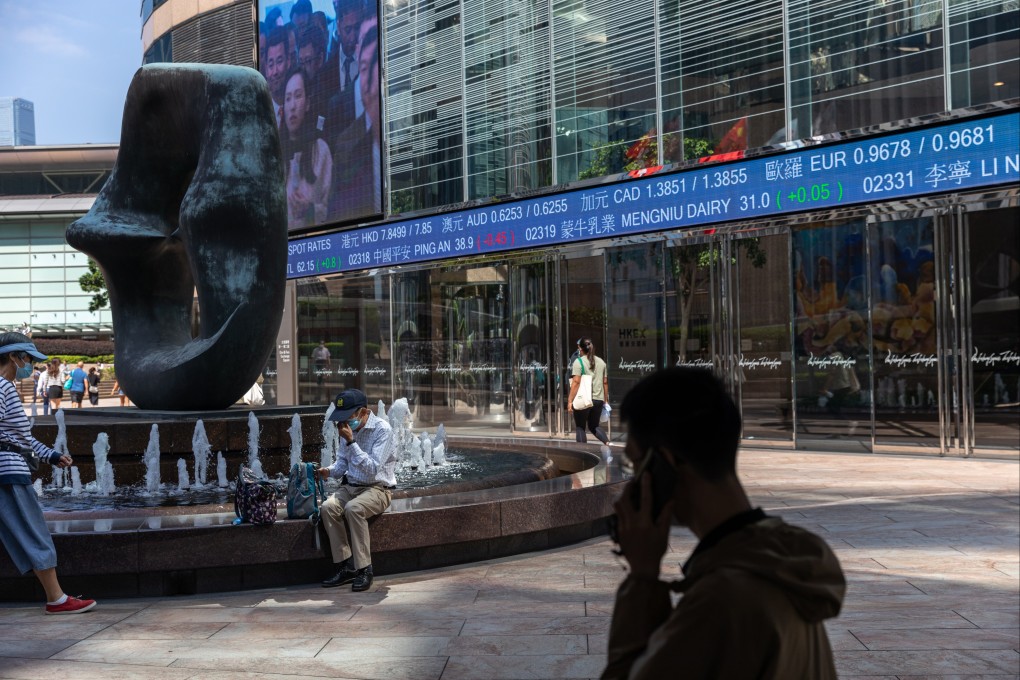 Pedestrians walk past a stock ticker displaying the Hang Seng Index in Hong Kong on October 11, 2022. Photo: EPA-EFE