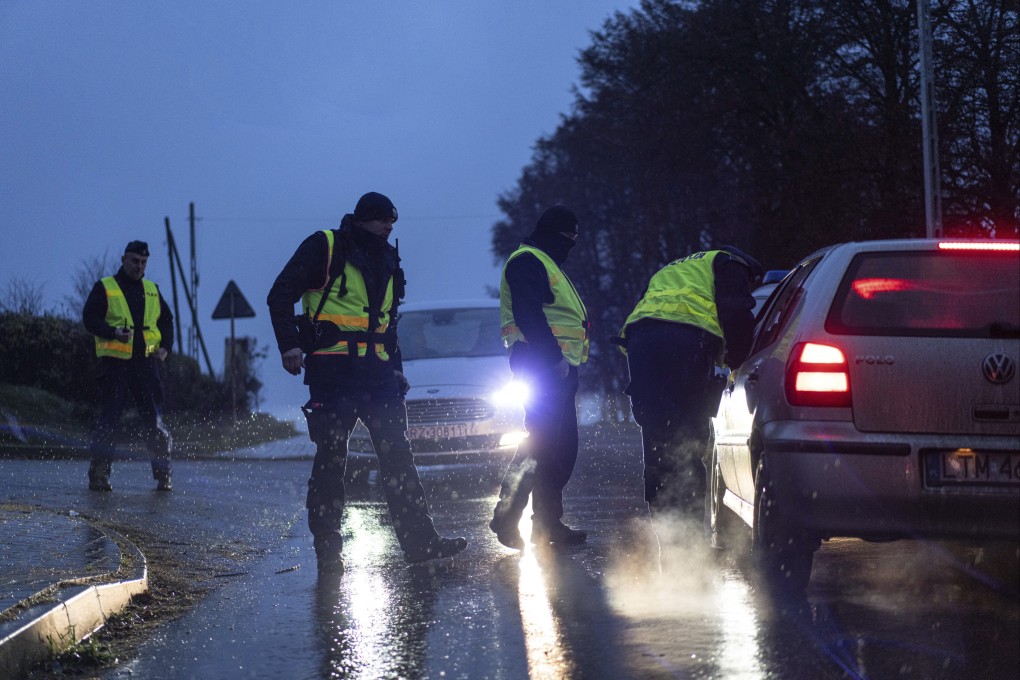 Police officers check documents at a checkpoint near the scene of a blast in Przewodow, Poland, on Wednesday. Photo: AP