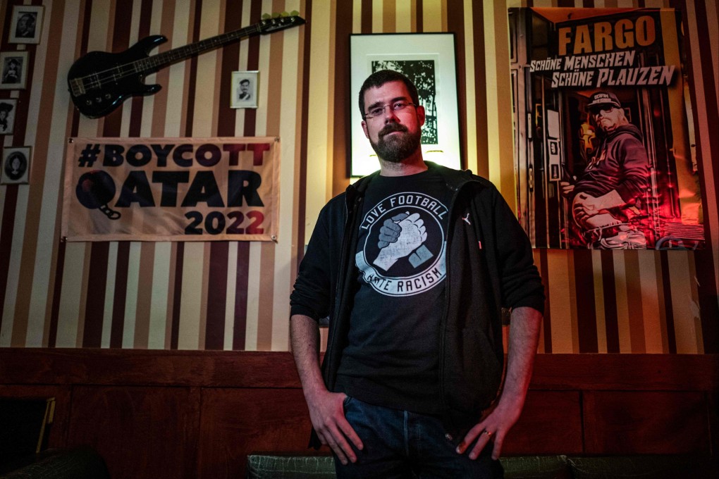 Football enthusiast and spokesperson for the Fargo bar Joschik Pech poses next to a ‘Boycott Qatar 2022’ banner in the Fargo bar in Berlin on November 10, 2022. Photo: AFP
