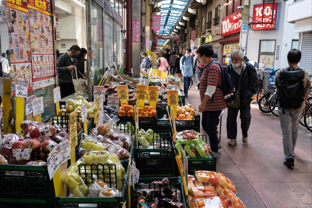 People look at fruit and vegetables outside a supermarket along a covered shopping street in Tokyo. Political analysts warn that Japan is paying the price for a succession of administrations that has failed to implement effective reforms in an economy in dire need of root-and-branch changes. Photo: AFP