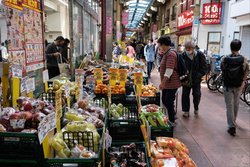 People look at fruit and vegetables outside a supermarket along a covered shopping street in Tokyo. Political analysts warn that Japan is paying the price for a succession of administrations that has failed to implement effective reforms in an economy in dire need of root-and-branch changes. Photo: AFP