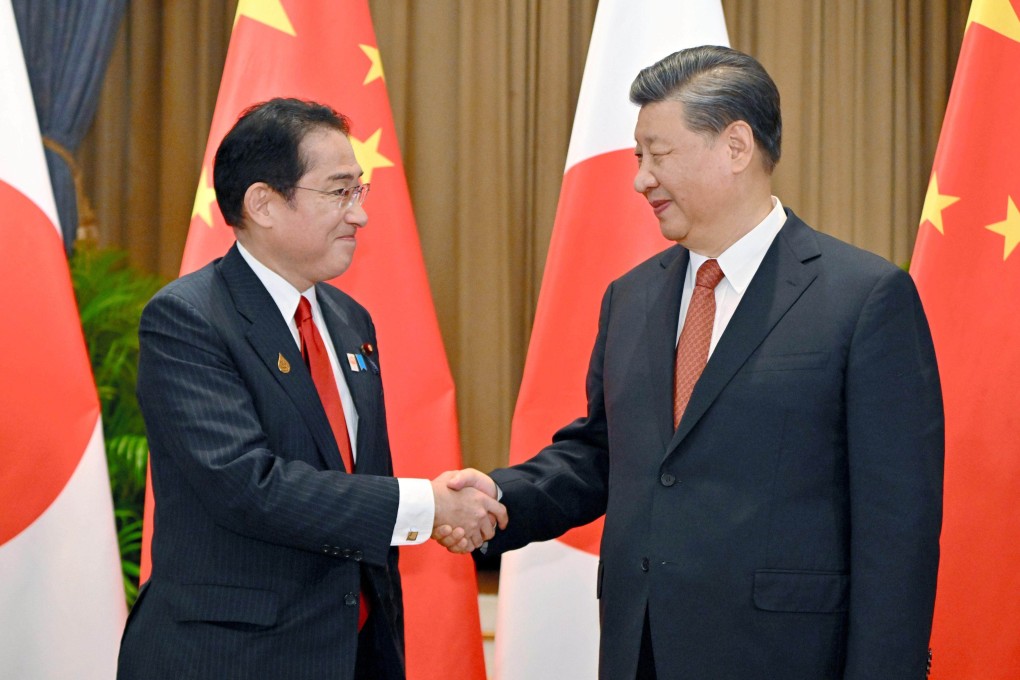 Fumio Kishida and Chinese President Xi Jinping shake hands at the start of their meeting in Bangkok. Photo: AP