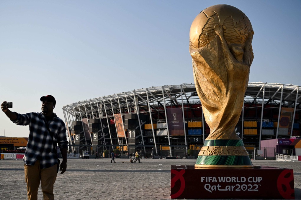 A man takes a picture in front of a replica of the World Cup trophy outside the Stadium 974 in Doha on November 15, 2022, ahead of the Qatar 2022 World Cup football tournament. Photo: AFP