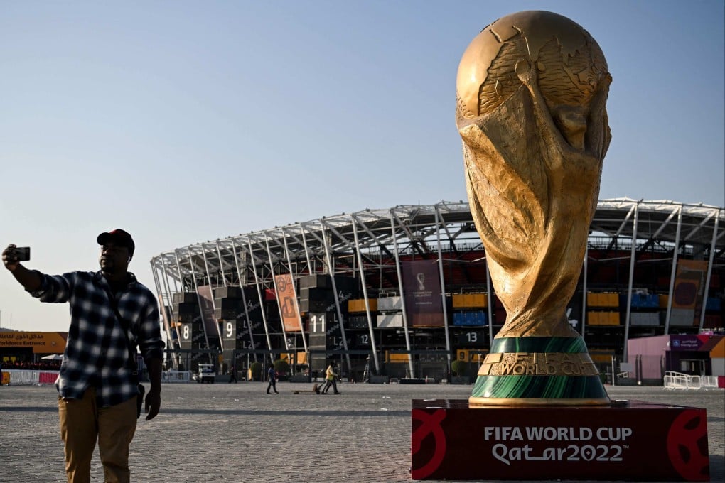 A man takes a picture in front of a replica of the World Cup trophy outside the Stadium 974 in Doha on November 15, 2022, ahead of the Qatar 2022 World Cup football tournament. Photo: AFP