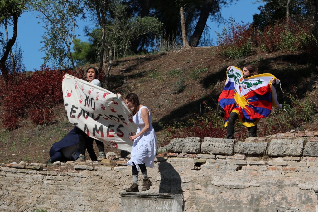 Protesters hold a Tibetan flag and a banner during the Olympic flame lighting ceremony at the Acropolis near Athens, Greece, for the Beijing 2022 Winter Olympics. Photo: Reuters