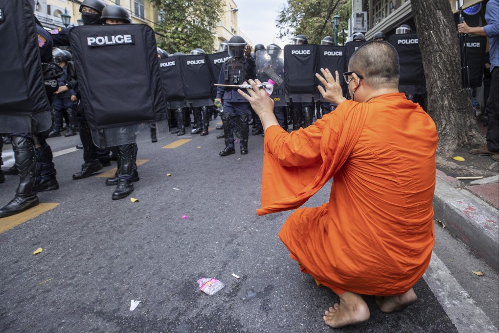 A monk raises his hands as police move to disperse protesters trying to march to the Apec summit venue on November 18 in Bangkok. Photo: AP