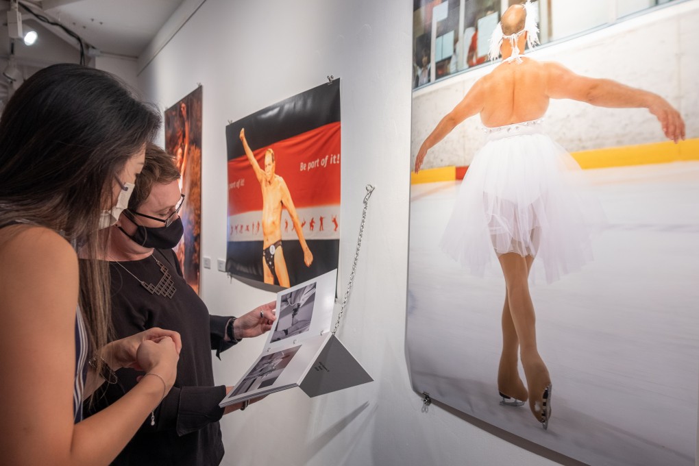 Visitors flip through a photo book of images from the 10th Gay Games, held in Paris in 2018, at the opening of “Beyond Strength: A Retrospective Exhibition of Gay Games, 1982-2022” at the Goethe Institute Hongkong. Photo: Connor Mycroft