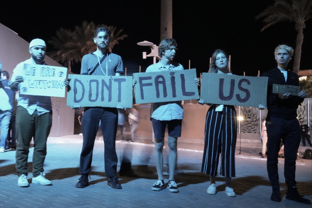 Activists hold signs at the COP27 UN Climate Summit in Sharm el-Sheikh, Egypt on Saturday. Photo: AP