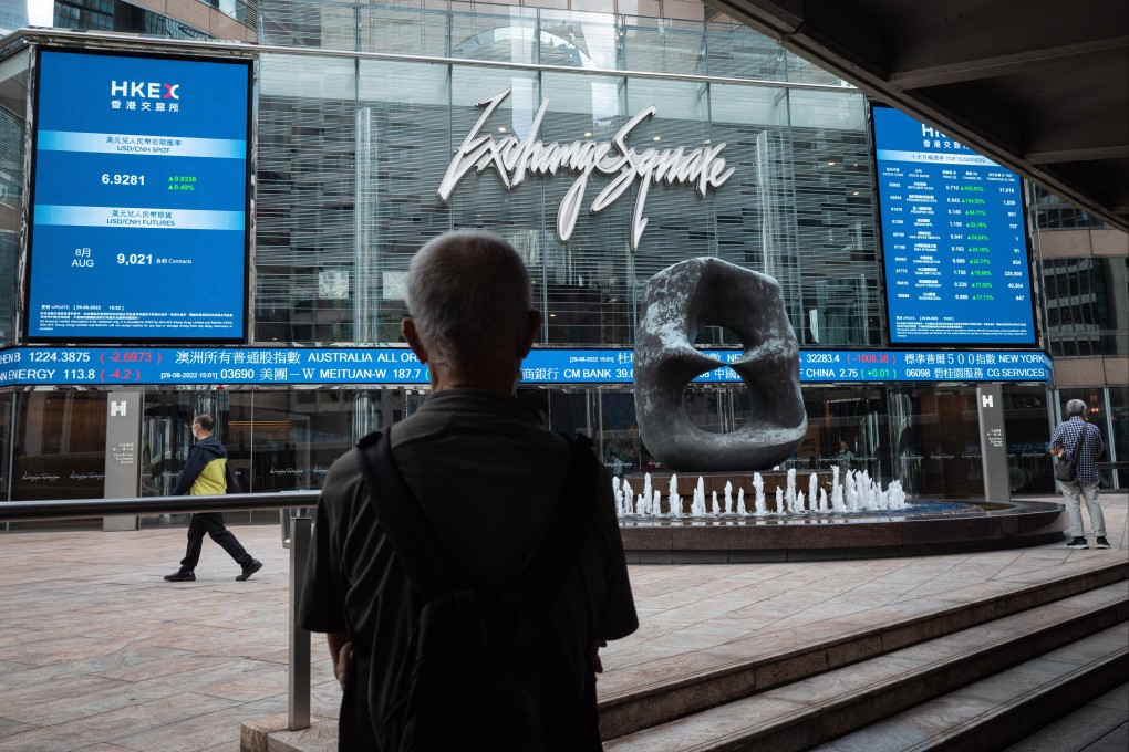 A man looks at electronic boards displaying the Hang Seng Index figure in Hong Kong in August 2022. Photo: EPA-EFE