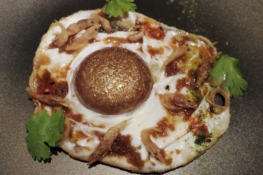 Singaporean chilli crab, miniaturised and repackaged into the yolk of a golden egg, at Disfrutar, in Barcelona, Spain. Photo: Victoria Burrows