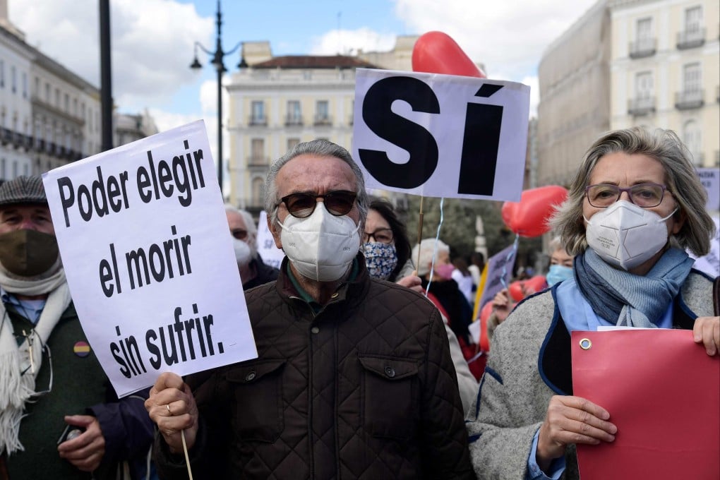 A man holds a placard reading “To choose to die without suffering” during a demonstration in support of a law legalising euthanasia in Madrid on March 18, 2021. Photo: AFP
