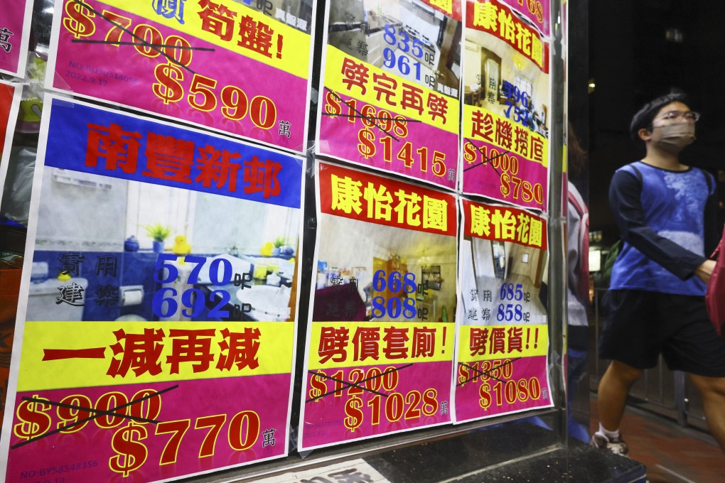 People walk past at residential property advertisements displayed in the window of an estate agency in Taikoo Shing on October 11, 2022. Property transactions are expected to hit a 32-year low of 64,000 this year. Photo: Dickson Lee
