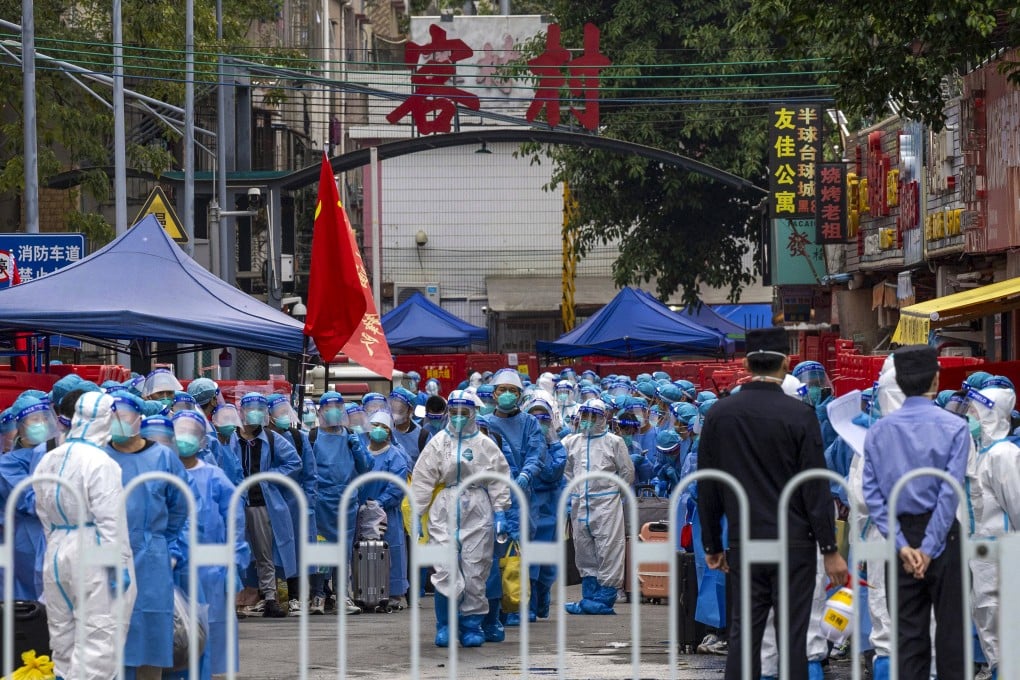 Residents in blue PPE prepare to be transferred from an urban village in Guangzhou, in southern China’s Guangdong province, to a Covid-19 quarantine centre. Photo: AP