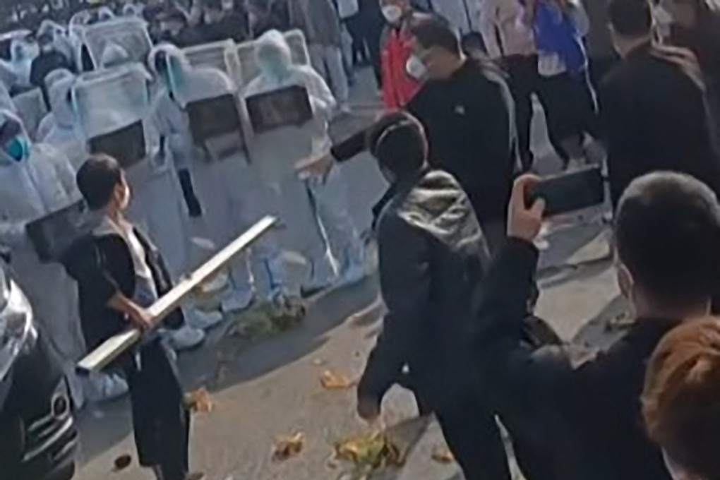 Workers at Foxconn Technology Group’s factory in Zhengzhou, capital of central Henan province, are seen squaring off with security forces and local police on November 23, 2022. Photo: Agence France-Presse