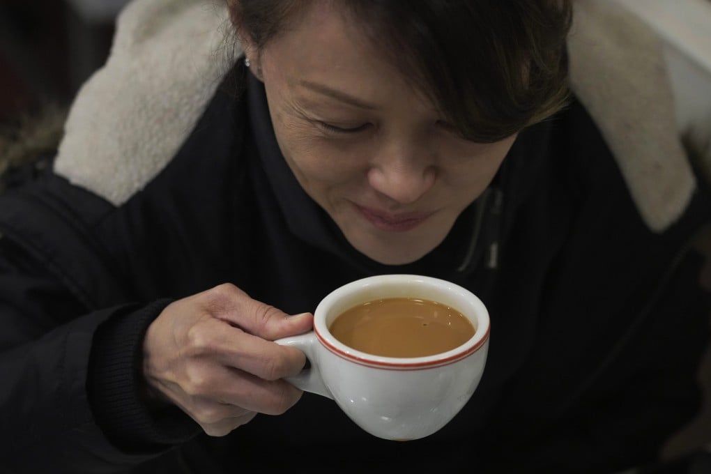 A customer drinks her Hong Kong-style milk tea in the Hoko Cafe in London. Workshops are popping up and milk tea businesses are expanding beyond Chinatowns in Britain. Photo: AP/Kin Cheung
