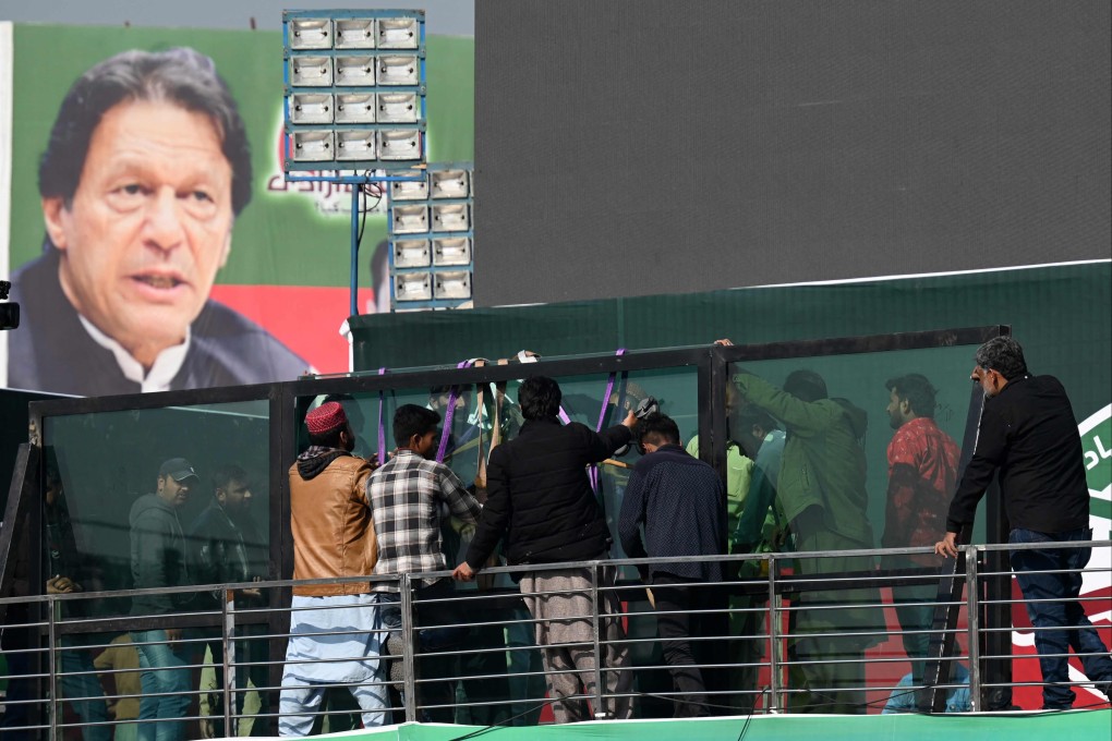 Workers install a bullet-proof glass shield on the main stage ahead of a rally lead by former Pakistan Prime Minister Imran Khan. Photo: AFP