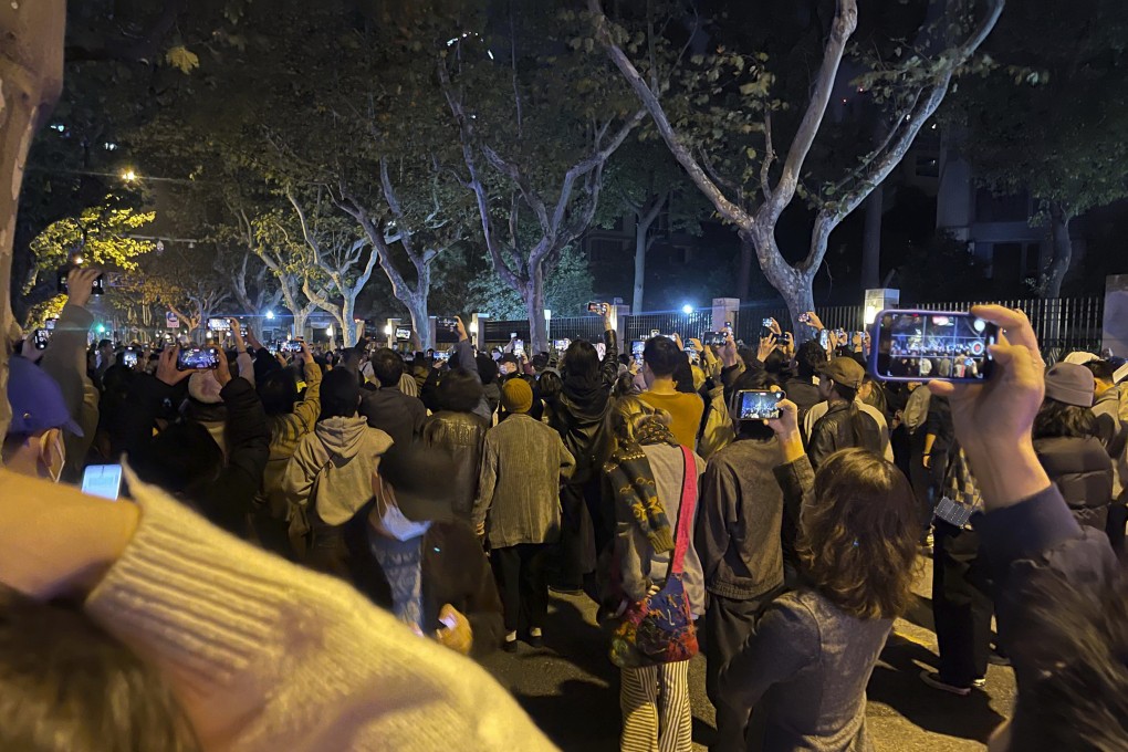 Demonstrators record the scene as they mourn the victims of the Urumqi fire, in Shanghai on Saturday.  Photo: AP