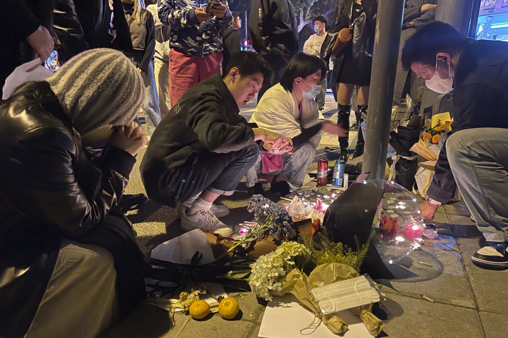 Residents pay tribute in Shanghai on Saturday to victims of a recent deadly fire in Xinjiang. Photo: AP