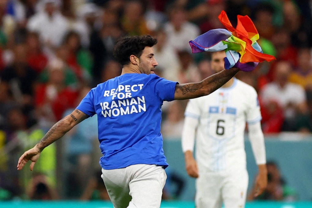 A protester runs onto the pitch wearing a respect for Iranian woman shirt. Photo: Reuters