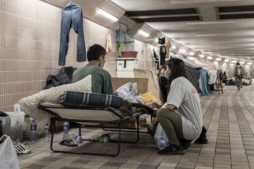 Volunteers from homeless-focused charity ImpactHK talk to a street sleeper in Hong Kong and provide a warm meal. Photo: Ben Marans